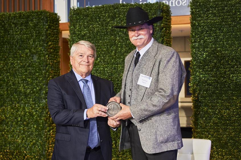 Rawland 卡 accepts his 校友 Fellow award from Penn State President Eric Barron.  